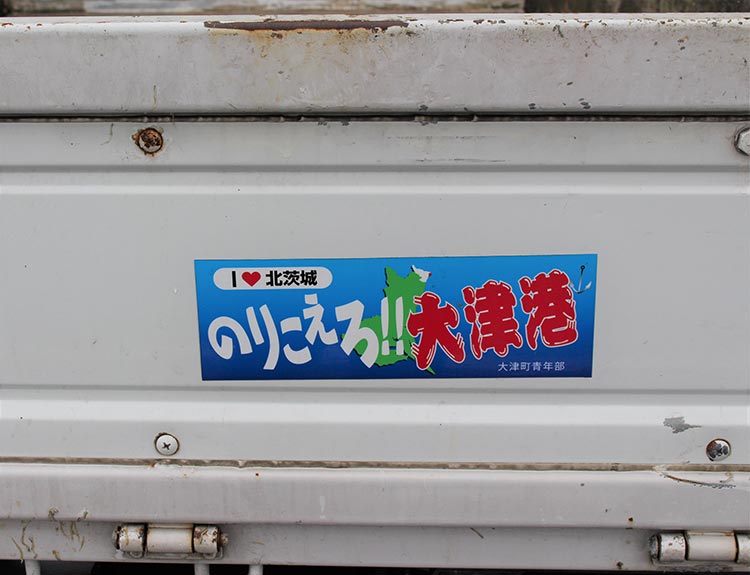 車の後ろには「乗り越えろ、大津港」のステッカー